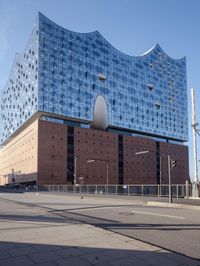 a big building with some windows next to a street corner and a few cars around it