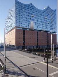 a big building with some windows next to a street corner and a few cars around it