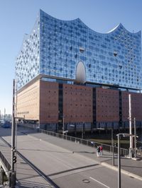 a big building with some windows next to a street corner and a few cars around it