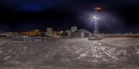 a stadium and field with some tall buildings in the background at night time with a blurry