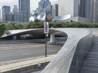 the top of a building next to highway with many tall buildings in the background and buildings on opposite sides