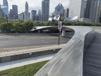 the top of a building next to highway with many tall buildings in the background and buildings on opposite sides