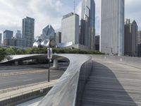 the top of a building next to highway with many tall buildings in the background and buildings on opposite sides