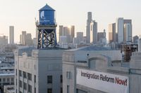 a blue water tower in a city over an empty building and a large sign reading union television