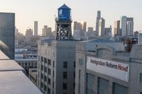 a blue water tower in a city over an empty building and a large sign reading union television