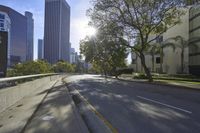 an empty street in front of a bunch of tall buildings on a sunny day,