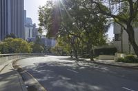 an empty street in front of a bunch of tall buildings on a sunny day,