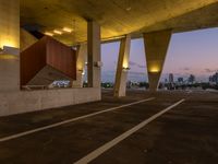 an empty parking lot surrounded by some concrete columns and lights on the sides of it