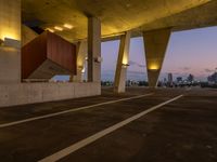 an empty parking lot surrounded by some concrete columns and lights on the sides of it