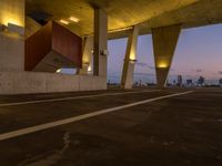 an empty parking lot surrounded by some concrete columns and lights on the sides of it