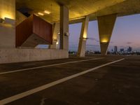 an empty parking lot surrounded by some concrete columns and lights on the sides of it