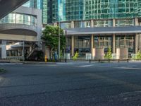 an empty road with a street sign at the curb in front of an office building