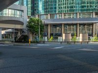 an empty road with a street sign at the curb in front of an office building