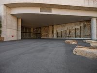 the entrance to a building is set up with three rocks in front of it and trees around the courtyard