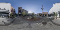 the view of a street from an intersection through a fisheye lens and the sun shining through