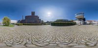 a panoramic shot of some buildings on the side walk in the middle of town