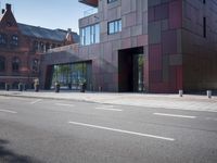 an empty street and an outside building on an urban day with a red and silver exterior