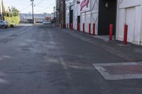 an empty street with traffic cones and parked cars on either side of it, with a sign near the end stating the space is empty