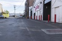 an empty street with traffic cones and parked cars on either side of it, with a sign near the end stating the space is empty
