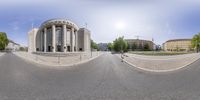 a 360 - pane view of a street next to a building in the daytime