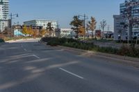 two empty street in front of an urban area and tall buildings in the background, with no cars on the side