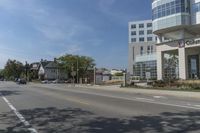 an empty city street in front of a building in a business area with cars and pedestrians