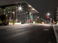 a car driving by the building at night time in motion with light trails coming out of it