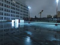 an empty parking lot in the middle of a big city at night with floody lights