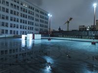 an empty parking lot in the middle of a big city at night with floody lights