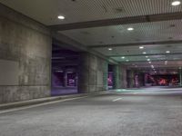 a view of a parking garage at night with a person standing on a red fire hydrant