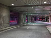 a view of a parking garage at night with a person standing on a red fire hydrant