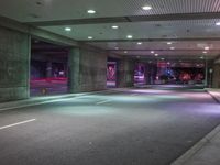 a view of a parking garage at night with a person standing on a red fire hydrant