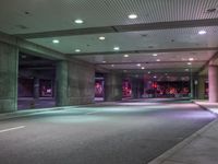 a view of a parking garage at night with a person standing on a red fire hydrant