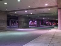 a view of a parking garage at night with a person standing on a red fire hydrant