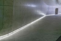 a man standing in a building looking down at an indoor tunnel underneath a bridge that is built to allow people walking on the ground