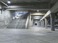 concrete steps are lined with concrete handrails and trees in the background at night