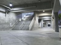 concrete steps are lined with concrete handrails and trees in the background at night