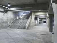 concrete steps are lined with concrete handrails and trees in the background at night