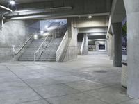 concrete steps are lined with concrete handrails and trees in the background at night