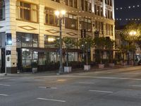 a road with some lights on either side and buildings with windows and many string lights above it