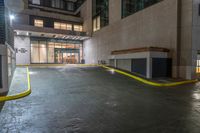 there is an empty parking garage on the street outside the building at night time with bright lights