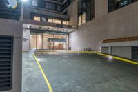 there is an empty parking garage on the street outside the building at night time with bright lights