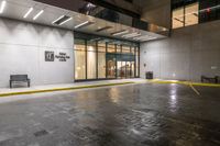 empty walkway at night outside an office building in the city with its entrance sign visible