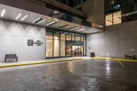 empty walkway at night outside an office building in the city with its entrance sign visible