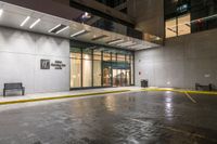 empty walkway at night outside an office building in the city with its entrance sign visible