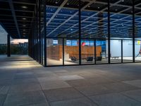 a walkway in the middle of a large building with multiple windows and a staircase next to it