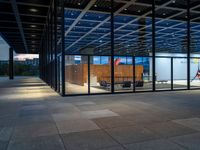 a walkway in the middle of a large building with multiple windows and a staircase next to it