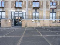 a parking lot with the doors opened to a building with balconies on it