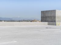 a parking lot with several signs on it that are in the distance with the mountains in the background