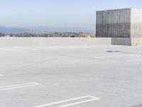 a parking lot with several signs on it that are in the distance with the mountains in the background